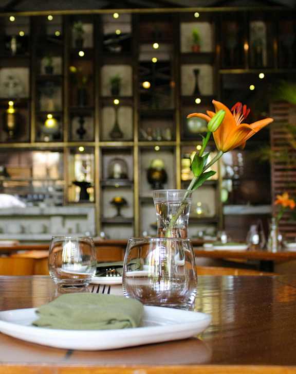a table with a plate and a vase with a flower