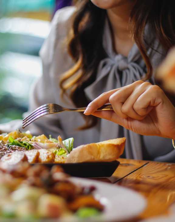 A woman is eating a meal at a restaurant.