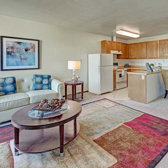 A living room with a couch a table and a chair at Alpine Apartments. 