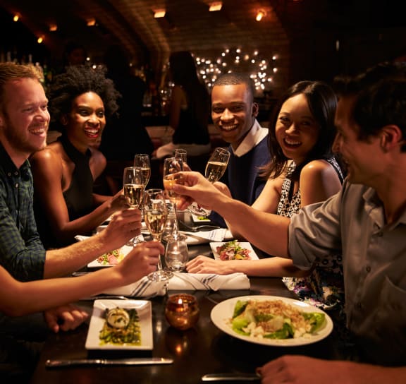 a group of people eating and drinking at a restaurant