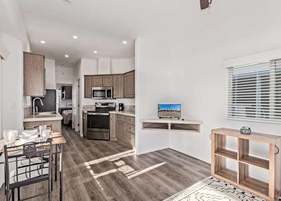 A kitchen with white cabinets and a black countertop.