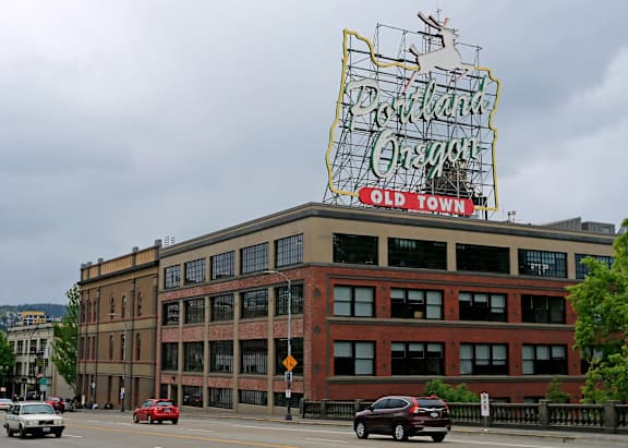 A large neon sign that says "Portland Oregon" is on top of a building.
