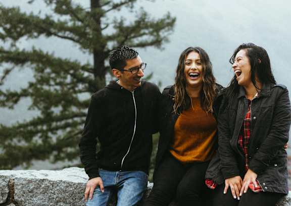 a group of people sitting on a stone wall