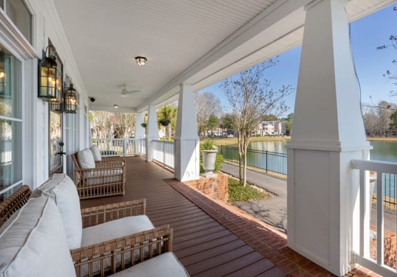 A covered patio overlooking the private lake with walking trail at The Reserve at Westcott apartments in Summerville, SC.