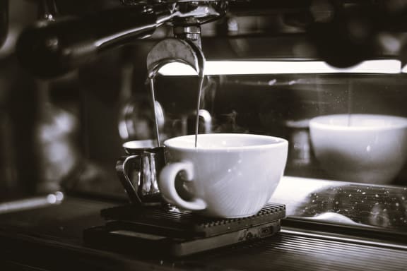 a coffee maker pouring coffee into a cup