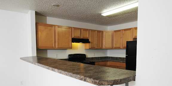 a kitchen with wooden cabinets and white appliances