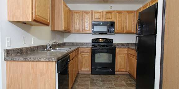 a kitchen with wooden cabinets and white appliances