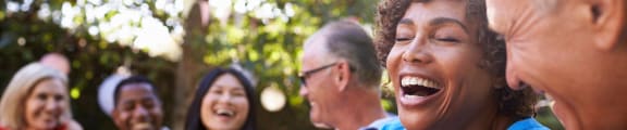 a group of people laughing and talking in a park