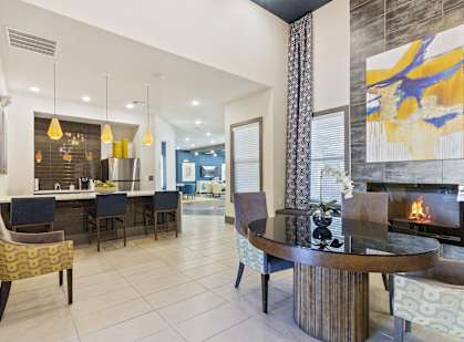 a living room with a fireplace and a table with chairs