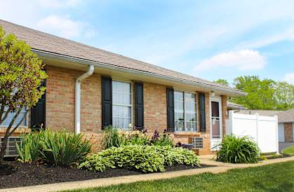 a brick house with black windows and a yard with plants  at Wyndemere Apartments, Franklin, 45005
