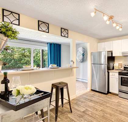 A kitchen with a stove, refrigerator, and oven.