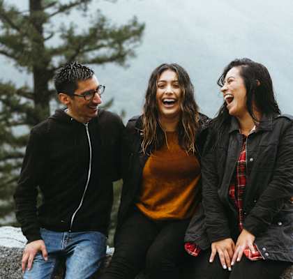 a group of people sitting on a stone wall
