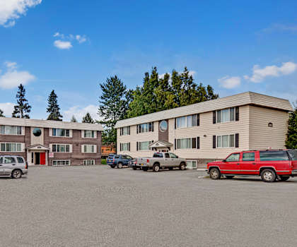 A parking lot with cars and a building in the background.