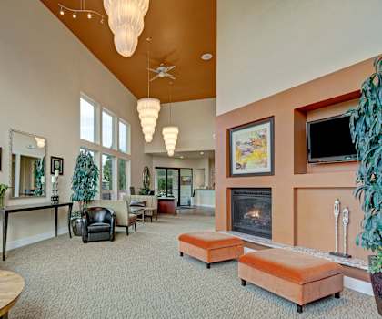 The lobby at the Alpine with couches, a TV, and a fireplace. 