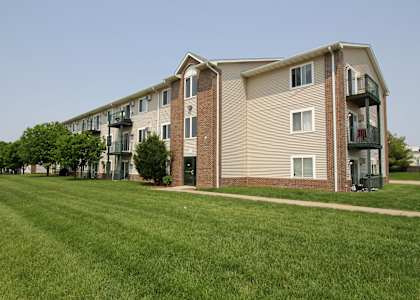 Apartment building with a green lawn in front.