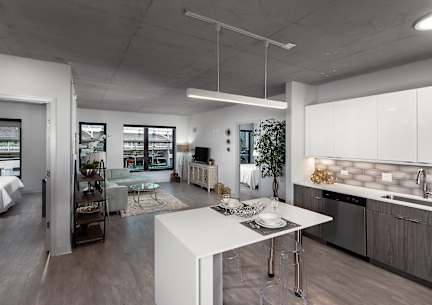 a kitchen and living room with a white island in the middle at Residences at Addison Clark Apartments, IL, 60613