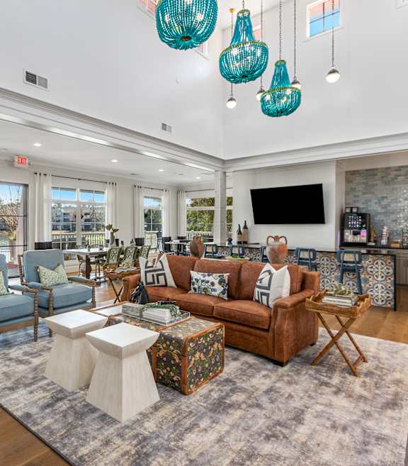 A living room with a brown couch and a TV on the wall.