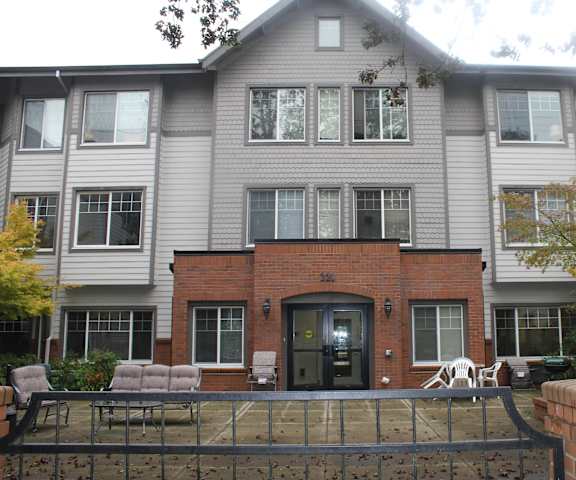 A grey building with a black door and windows.