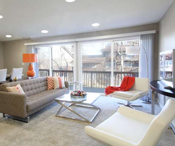 A living room with a grey couch and a white chair.