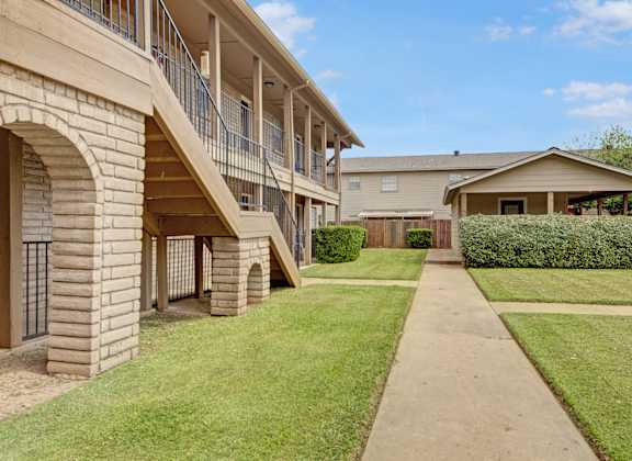 A building with a balcony and a walkway in front.