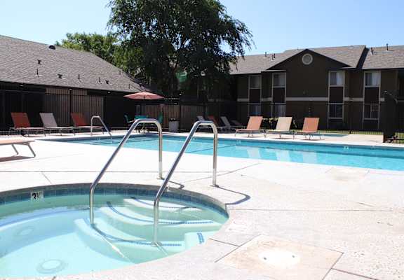 A hot tub sits in the middle of a pool surrounded by chairs.