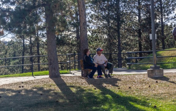 two people sitting on a bench in a park  at Antelope Ridge, Box Elder, South Dakota