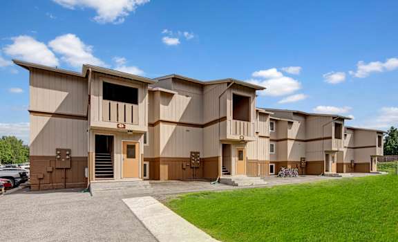 A row of identical houses with brown siding and tan doors.