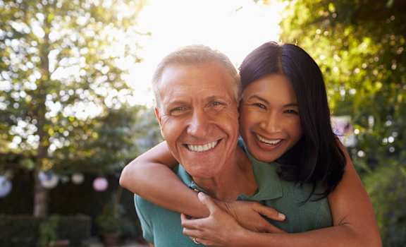 an older man and a young woman hugging each other