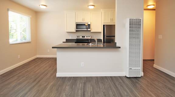a kitchen with a counter top and a refrigerator and a microwave