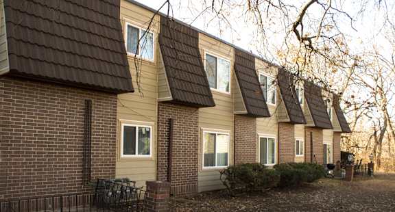 A row of houses with a black fence in front.