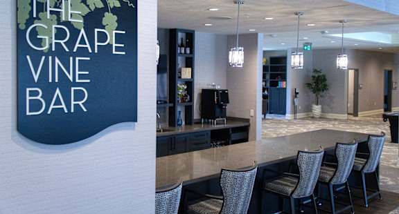 a view of the grape vine bar with chairs and a sign on the wall