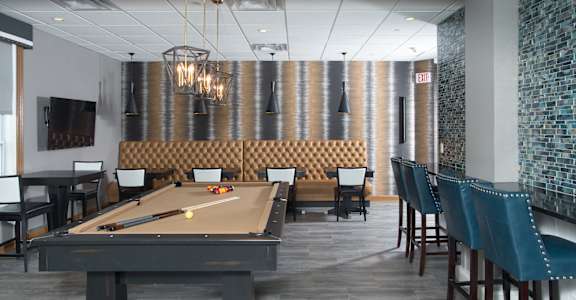 A pool table in a room with a striped wallpaper.