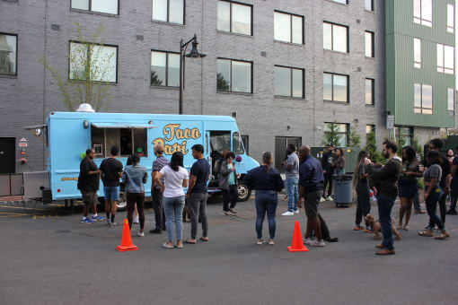 a group of people standing in front of a food truck