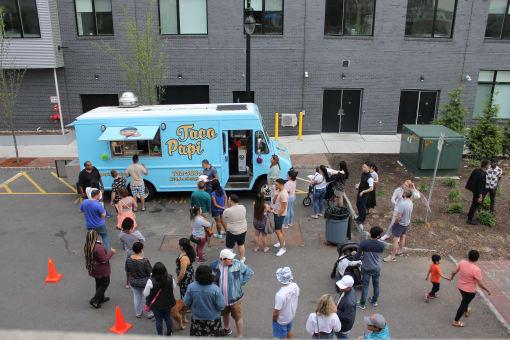 a crowd of people standing in front of a food truck