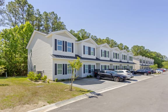 a row of houses with cars parked in front of them at Waverly Place, North Charleston, SC, 29418