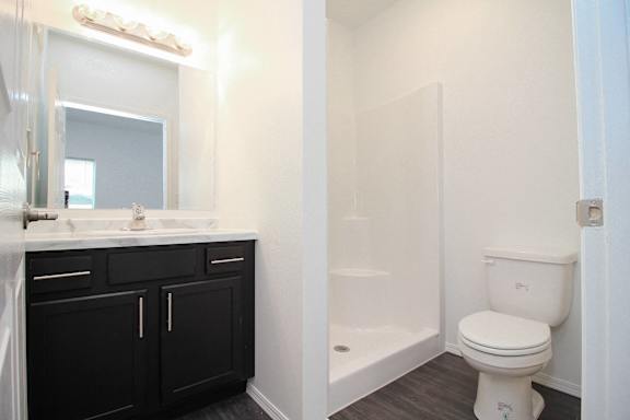 A white toilet sits next to a bathtub in a bathroom.