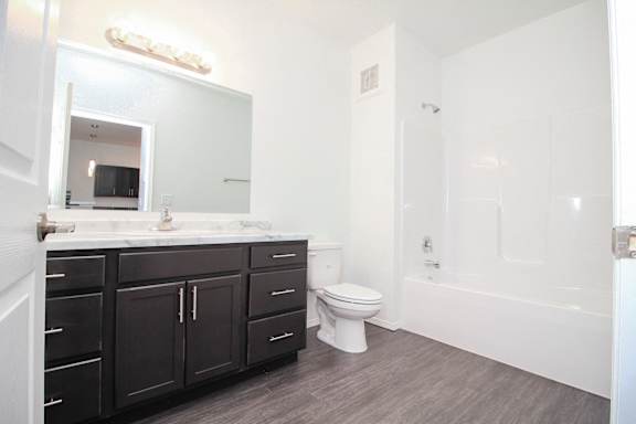 A white bathroom with a toilet, sink, and bathtub.