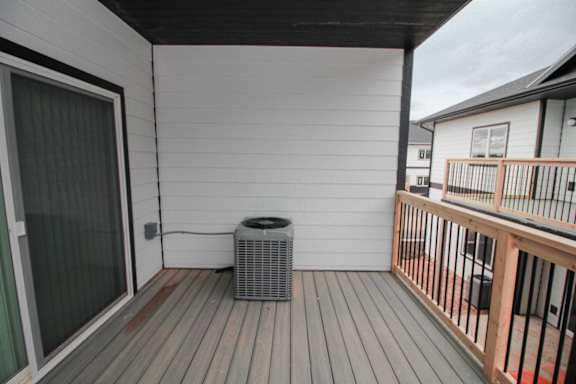 A patio with a sliding glass door and a wood deck.