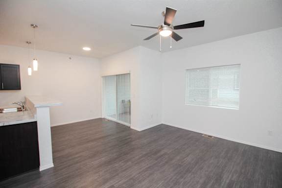 A room with a ceiling fan and a counter.