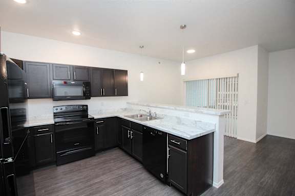 A kitchen with black cabinets and a white countertop.