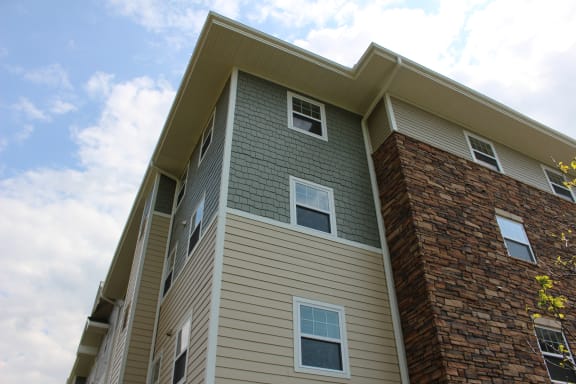 the exterior of a large apartment building with brown and green siding