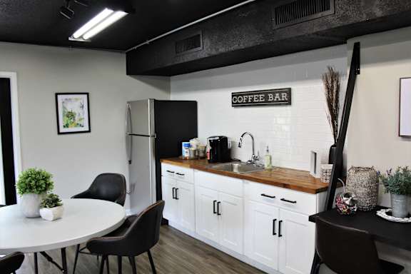 a kitchen with white cabinets and a coffee bar in a room with a dining table at Capital Flats & Magnolia Square Apartments, Raleigh, NC