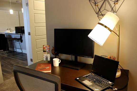 a desk with a laptop and a computer monitor at CityWay Apartments, Indianapolis