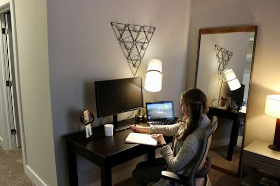 a woman sitting at a desk in front of a computer at CityWay Apartments, Indianapolis