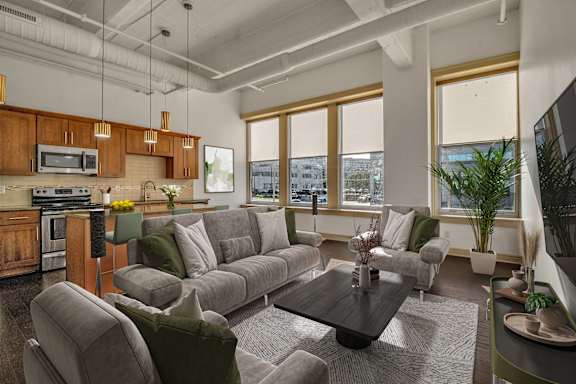 A modern living room with a grey sofa set and a wooden coffee table.