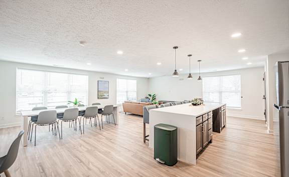 A modern kitchen with a dining table and chairs.
