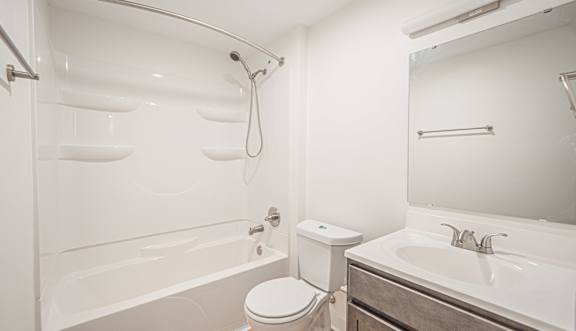 A white bathroom with a toilet, sink, and bathtub.