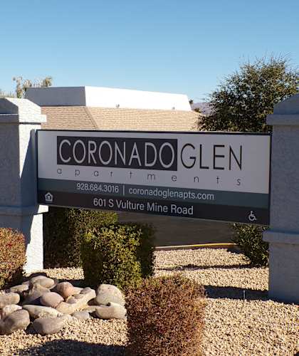 A sign for Coronado Glen Apartments with a phone number and website listed.