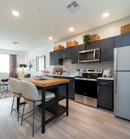 A modern kitchen with a dining table and chairs.
