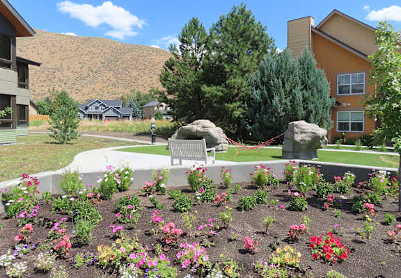 a park bench in front of a garden with flowers